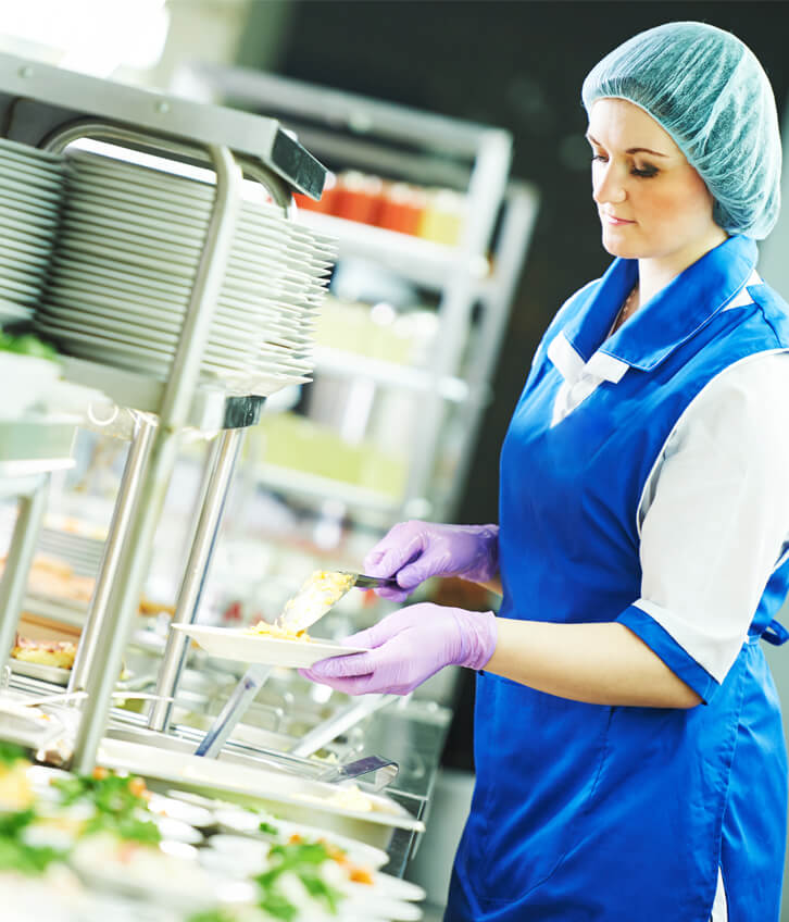 Metro Canteens Adelaide, canteen service providers image of a lady dishing up a meal at a canteen.