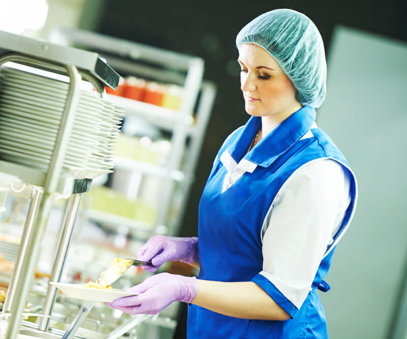 Metro Canteens Adelaide, canteen service providers image of a lady dishing up a meal at a canteen.